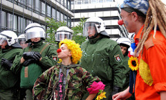Clandestine Insurgent Rebel Clown Army / CIRCA; Heimliche Aufständische Rebellen-Clownarmee: Clown Demonstranten bei der Arbeit - Polizisten schauen zu.