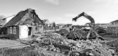 Abriss vom Bauernhof Ahlers im Dorfring von Wilstedt / Ortsteil in Tangstedt. Reste vom reetgedeckten Wohnhaus - Bauschutt, Bagger beim Sortieren in Container.