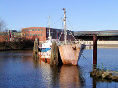 Altes rostiges Schiff im Moldauhafen Hamburg Kleiner Grasbrook - im Hintergrund das Lagerhaus D und das Übersee-Zentrum. Das Hafenbecken Moldauhafen wurde  1887 gebaut - ein 30.000 Quadratmeter großes Gelände wurde aufgrund des nach dem Ersten We