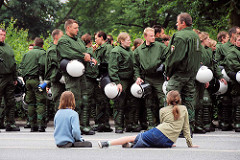 Ruhe vor dem Sturm - Mädchen sitzen auf der Straße, die Polizeimanschaften sammeln sich. Demonstation am Millerntor in Hamburg St. Pauli.