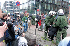 Demonstration in Hamburg - Ludwig Erhard Straße; zwei Polizisten nehmen einen Demonstranten fest; er wird über einen Parkpoller gedrückt - Fotografen bei der Arbeit.