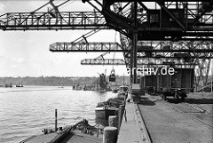 a Kohleverladebrücken im Hamburger Kohlehafen - Schuten liegen am Kai, auf dem Kai Güterwaggons.
