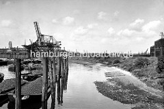 a Abgeböschtes Ufer vom Kohlehafen im Hamburger Hafen - Schuten mit Kohle beladen leigen an Dalben - im Hintergrund Kohleverladebrücken.