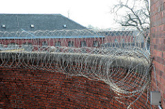 Gefängnismauer mit Stacheldraht - alte Ziegelmauer der Hamburger Justizvollzugsanstalt Fuhlsbüttel - Santa Fu.