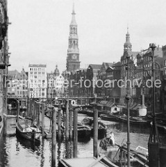 Alte Fotografie vom Nikolaifleet in der Altstadt Hamburgs - Schuten und Ewer liegen am Fleet; Speichergebäude und Kontorhäuser - Kirchturm der St. Katharinenkirche.