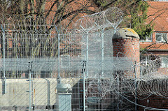 Gefängnismauer mit Gitter und Stacheldraht - alte Ziegelsäule der Hamburger Justizvollzugsanstalt Fuhlsbüttel - Santa Fu.