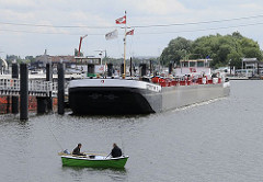 Zwei Männer sitzen in einem Ruderboot und angeln  - sie halten mehrere Angeln in das Wasser der in der Billwerder Bucht.