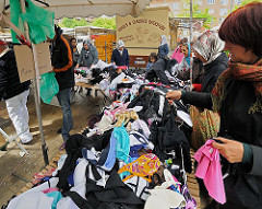 Langer Verkaufstisch mit Kleidung auf dem Wilhelmsburger Wochenmarkt, der zweimal in der Woche auf dem Stübenplatz stattfindet.