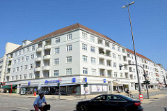 Wohnhaus mit weißer Fassade Balkons, im Erdgeschoss eine Hamburger Drogeriekette;  Architekturbilder aus Hamburg Barmbek Nord