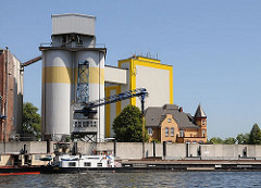 Diamant-Mehl Getreidesilo + Getreidemühle am Reiherstieg - ein Binnenschiff liegt an der Kaimauer; seine Fracht wird über eine Sauganlage gelöscht und in das Silo transportiert.
