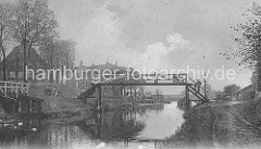 altes Bild vom Ernst-August-Kanal - eine Fussgängerbrücke aus Holz verbindet die beiden Kanalufer; Wege führen am Rand des Kanals entlang,
