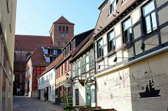 Historische Wohnhäuser in der Schulstraße / Altstadt von Waren - Wandbild mit Stadtpanorama und Angler; im Hintergrund die St. Georgen.
