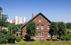 Altes Bauernhaus im Hamburg-Stillhorn am Deich zur Süderelbe - Linden stehen vor dem Ziegelgebäude.
