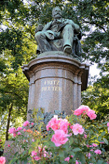 Fritz Reuter Denkmal in Neubrandenburg, blühende Rosen. Das Denkmal wurde zu Ehren des Dichters, der von 1856 bis 1863 in der Stadt lebte.