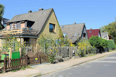 Einzelhäuser  mit Satteldach  und kleinem Vorgarten - unterschiedliche Fassaden Gestaltung; ruhige Seitenstraße in Hamburg Bramfeld.