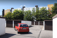 Garagenanlage in der Wohnsiedlung Kirchdorf Süd. Ein roter PKW verlässt seinen Stellplatz und wird zur Strasse gefahren.