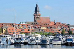 Sportboothafen / Marina in Waren an der Müritz; Sportboote mit Bimini, Sonnensegel / Bimini am Steg - im Hintergrund die St. Marienkirche.