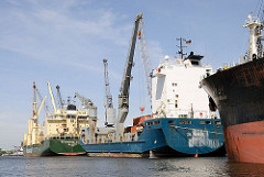 Mehrere Frachter liegen am Reiherstiegkai; in der Mitte die 100m lange und 20m breit OXL NOMAD.  Die bordeigenen Krane / Ladegeschirr machen das Schiff beim Laden und Löschen.