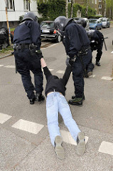 Ein Demonstrant wird von freundlichen Polizisten um Begleitung gebeten -  Demonstration in Hamburg Barmbek.