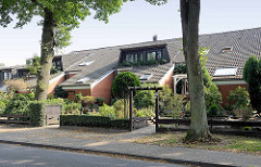 Reihenhäuser mit tief heruntergezogenen Dach - Fenstergauben mit Balkon; bunkerähnliche Architektur in Maschen.
