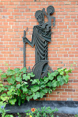 Metallrelief des heiligen Christophorus  mit Jesus auf der Schulter - Hausfassade der Christophorus Kirche in Hamburg Hummelsbüttel.
