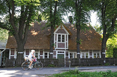 Strohdachhaus in Hamburg-Georgswerder; die Fachwerkbalken des historischen Gebäudes sind weiss gestrichen.