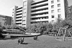 Hochhaussiedlung in Hamburg Hummelsbütte - einsame Wackelschnecken auf dem Kinderspielplatz mit Rutsche und Schaukel.