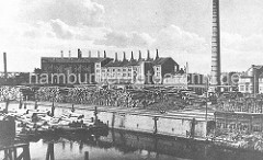 Historisches Foto aus Hamburg Wilhelmsburg ca. 1920 - am Ufer des Veringkanals sind Baumstämme gestapelt; an den Kaianlagen liegen Schuten.