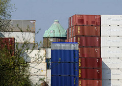 Die kupferne Kuppel des 1911 erbauten Wilhelmsburger Wasserturms ist hinter den am Ufer des Schmidtkanals gelagerten Container zu erkennen.