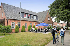 Altes Schulgebäude an der Schulstraße in Maschen; jetzt Nutzung als Restaurant mit Außengastronomie.