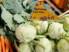 Auf dem Wilhelmsburger Wochenmarkt wird Gemüse aus Moorwerder angeboten; frischer Moorwerder Kohlrabi liegt in der Kiste, daneben frische Möhren.