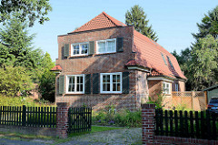 Backsteinarchitektur der 1930er Jahre - Stadtvilla mit Blendgiebel und Krüppelwalmdach, Holzläden an den Fenstern.  Architekturfotos aus Hamburg Fuhlsbüttel.