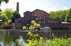 Blick über den Veringkanal zum Industriegebäude mit hohem Schornstein, das 1906 errichtet wurde.