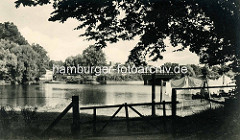 Historische Ansicht vom Mühlenteich in Hamburg Fuhlsbüttel; Stacheldrahtzaun und Holzgatter, Wäsche ist zum Trocknen aufgehängt. Im Hintergrund  die Brücke Ratsmühlendamm.