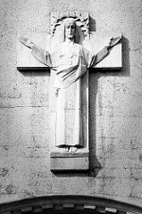 Segnende Jesusfigur am Kreuz über dem Eingang der katholischen Herz-Jesu-Kirche in Stettin.