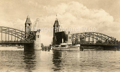 Altes Foto von der Hansabrücke über die Oder in Stettin; die Klappbrücke ist hochgefahren, eine Barkasse fährt durch die Öffnung - auf der Brücke stehen die wartenden Menschen dicht gedrängt.