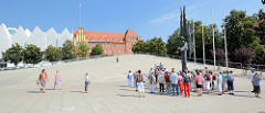 Eine Touristengruppe steht auf dem Plac Solidarnoci vor der 9 Tonnen schweren Skulptur Engel der Freiheit - Künstler Anioł Wolności.