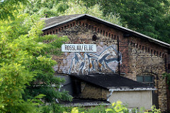 Alter Ziegelschuppen mit Graffiti am Bahnhof / Schild Roßlau Elbe.