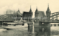 Historische Fotografie von der Bahnhofsbrücke über die Oder in Stettin, die Klappbrücke ist aufgeklappt - ein Fahrgastschiff fährt unter Dampf hindurch.