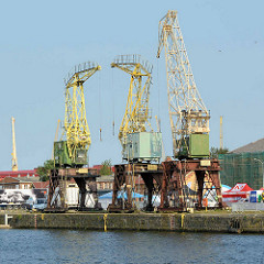 Alte Hafenkräne / Bauform Wippkran stehen an einem Kai an der Oder in Stettin