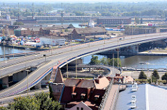 Luftaufnahme vom Hafengebiet einer oder in Stettin; moderne Autobrücken führen über den Fluss, rechts unten der Frauentum.