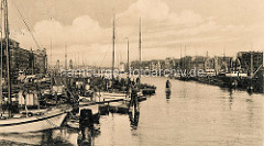 Historisches Foto vom Hafengebiet an der Oder in Stettin; Schiffe liegen dicht gedrängt an der Hafenpromenade, dahinter Wohnhäuser / Geschäftshäuser.