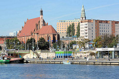 Blick über die West-Oder zu Uferpromenade in Stettin; gotisches Bauwerk / Backsteingotik der St.-Johannes-Evangelist-Kirche (Johanneskirche).