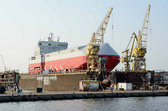 Ein Schiff liegt im Trockendock dder Stettiner Werft / Stocznia Szczecińska.