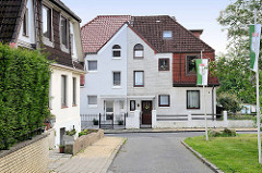 Einstöckiges Doppelhaus mit unterschiedlicher Fassadengestaltung in Hamburg Wilstorf.