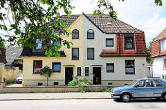 Einstöckiges Doppelhaus mit unterschiedlicher Fassadengestaltung in Hamburg Wilstorf.