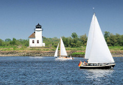 Segelboote mit weissen Segeln auf der Elbe vor dem Leuchtfeuer Julesand.
