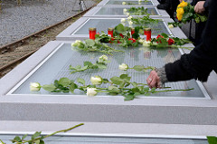 Die Tafeln mit den Namen der über 8000 deportenierten Juden, Sinti und Roma werden zum Gedenken mit weissen Rosen geschmückt.