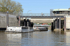 Ein Schleppverband  mit Schuten fährt vom Oberhafenkanal  in die Brandshofer Schleuse ein. Radfahrer auf dem Elberadweg in Hamburg Rothenburgsort.