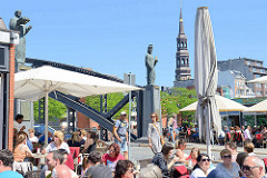 Sommer in der Hansestadt Hamburg - Cafés an der Brooksbrücke in der Hamburger Speicherstadt. Brücken-Skulpturen von Sankt Ansgar und Friedrich I.